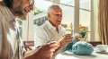 Senior friends enjoying knitting at home. Elderly men making woollen warm wear at home.